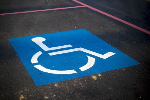 Image of a wheelchair disability sign that has been painted on a car park