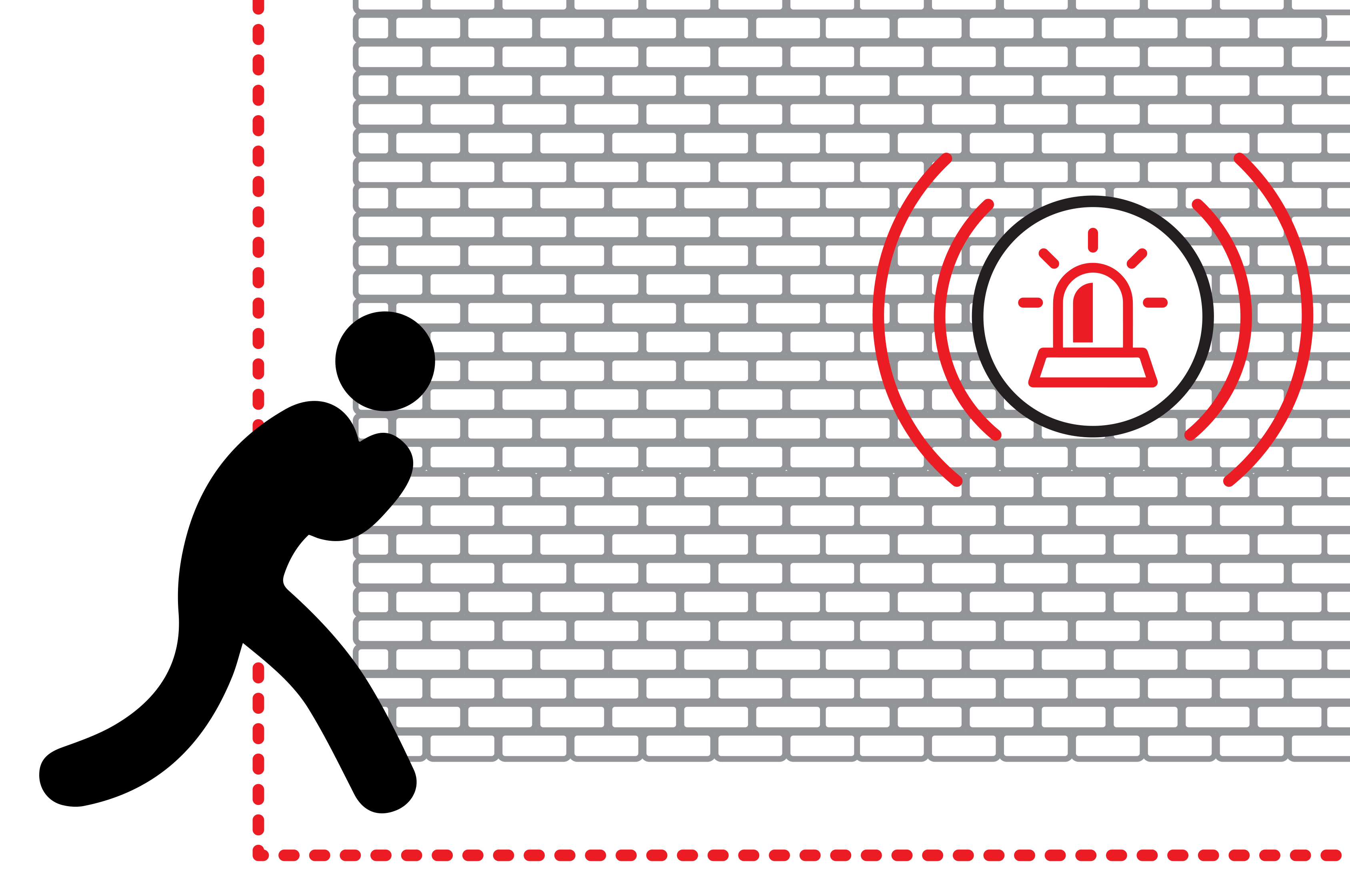 Person crouching beside a brick wall while a flashing alarm or warning siren is mounted on the wall.